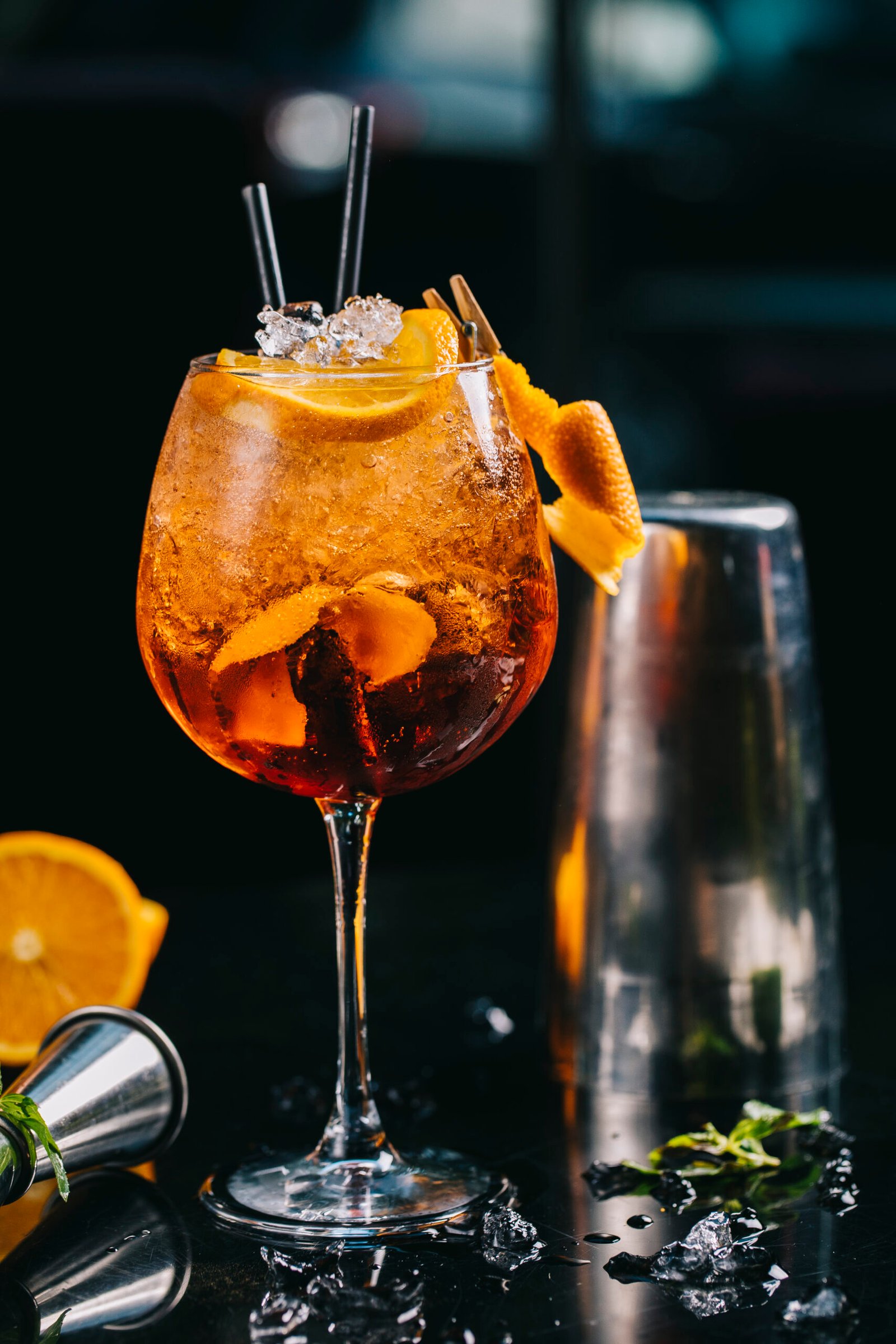 About orange cocktail inside glass with minced ice cubes pipes